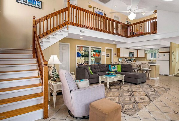 A spacious living area with a staircase, a dining area, and a kitchen.
