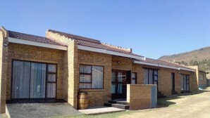 Una hilera de casas de ladrillo con ventanas amplias y techo plano.