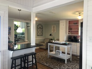 A compact kitchen with a bar area, white cabinetry, and a patterned rug. - FALL DATES AVAILABLE! Special discounts! Flexible check in days (Holden Beach)