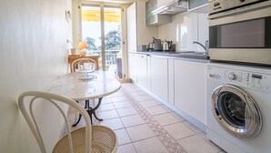 Una cocina compacta equipada con horno, microondas y lavadora.