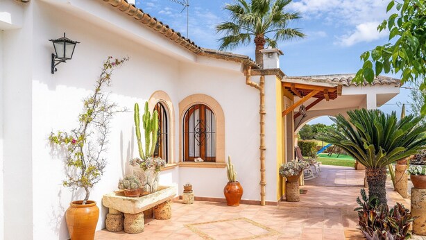A courtyard with a tiled floor, potted plants, a bench, and a pergola structure. - Charming Villa “Finca Santa Eulalia Petit” with Porch and Pool (Can Picafort)