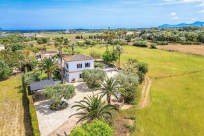 Une villa dotée d’une cour intérieure, entourée de verdure et offrant une vue sur la mer.