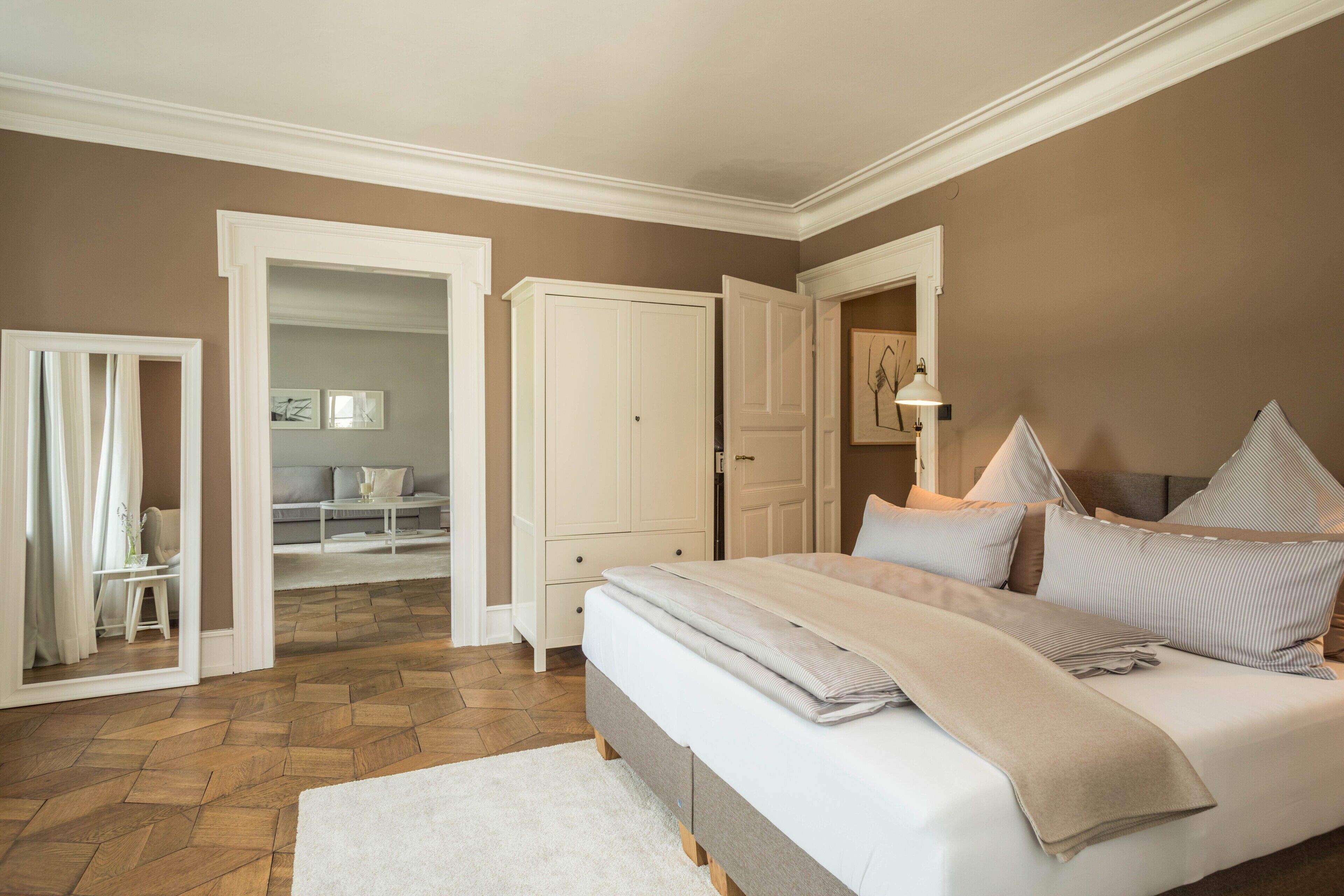 Ein Schlafzimmer mit einem Bett, einem Kleiderschrank und einer Tür zu einem anderen Raum.