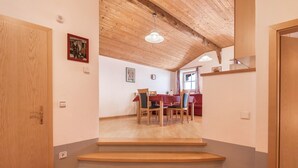 A wooden staircase leading to a dining area with chairs and a table.