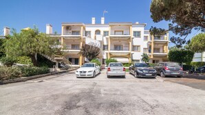 A multi-story building with a parking lot in front. - Beautiful Marjoh AL Holiday Apartment with Pool, Balcony, Air Conditioning and Wi-Fi (Vilamoura, Quarteira)