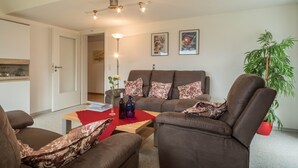 A living room with a sofa, armchairs, a coffee table, and a potted plant. - High-Quality Apartment “Ferienwohnung Steinhilber 1” (Eriskirch)