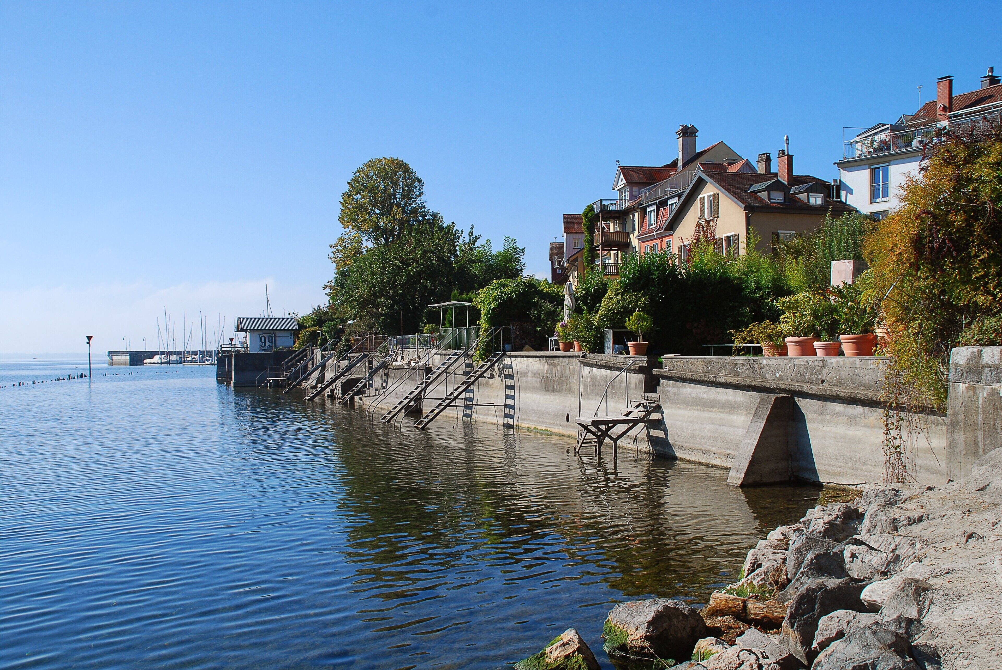 A waterfront property with a stone bridge, a row of houses, and a clear view of the water.