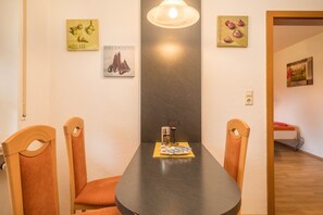 A dining area with a table, chairs, and wall art.