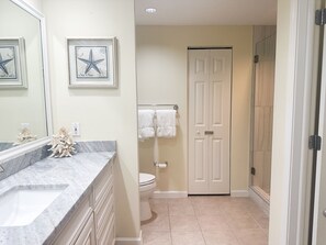 Een bad/douchecombinatie, een haardroger, handdoeken, zeep