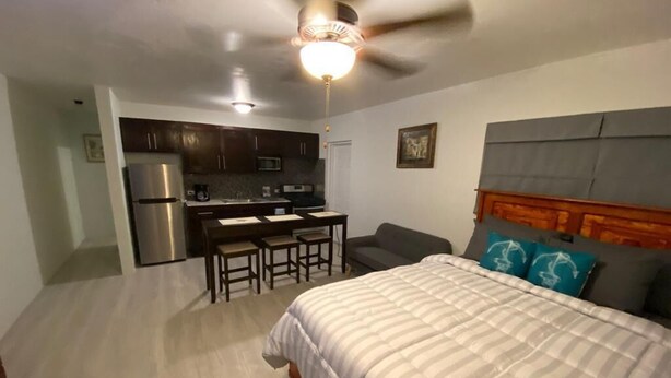 A bedroom with a bed, a desk, and a kitchenette. - Cozy Villa in Nassau with homely feel in quiet neighborhood.  (Nassau)