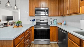 Een moderne keuken met houten kastjes, roestvrijstalen apparatuur en een centraal eiland.
