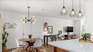 Een moderne keuken met een centraal eiland, hanglampen en een eethoek met een vachttapijt.
