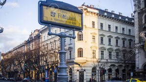 A street sign with the text "Opera Fődalmati a Vörösmarty tér felé" in front of a classical building with arched windows and a detailed facade. - THE TOTAL APPARTMENT IS YOURS ALONE (BUDAPEST)