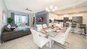 Una cocina moderna con comedor, un televisor de pantalla plana grande y un ventilador de techo.