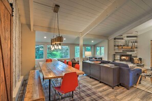 Relax in a spacious living area with a dining table, sofa, and bench near a fireplace.