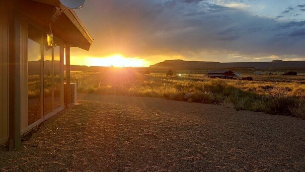 A building with a satellite dish, a gravel path, and a sunset in the background. - Little Ranch Home near National Parks & Lake Powell (Clark Bench)