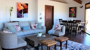 A living room with a sofa, armchairs, a coffee table, and a dining area with chairs and a table. - Little Ranch Home near National Parks & Lake Powell (Clark Bench)