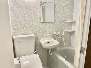 Un baño con inodoro, lavamanos y bañera.