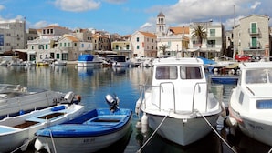 A marina with various boats docked, surrounded by buildings with traditional architecture. - Stunning private villa with hot tub, A/C, WIFI, private pool, TV, patio and pets allowed (Vodice)