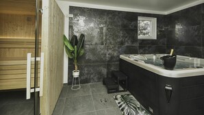 A modern bathroom with a sauna, a large black bathtub, and a potted plant. - Stunning private villa with hot tub, A/C, WIFI, private pool, TV, patio and pets allowed (Vodice)