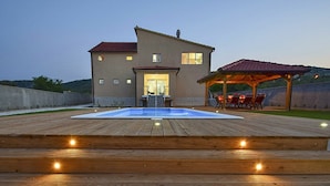 A house with a swimming pool, wooden deck, and outdoor seating area. - Stunning private villa with hot tub, A/C, WIFI, private pool, TV, patio and pets allowed (Vodice)