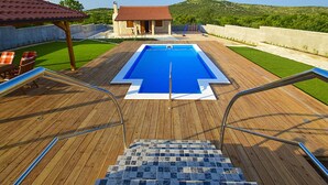A wooden deck with a swimming pool, a small building, and a view of hills. - Stunning private villa with hot tub, A/C, WIFI, private pool, TV, patio and pets allowed (Vodice)