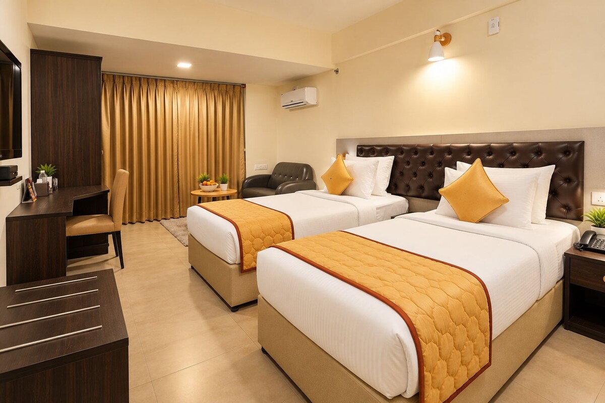A hotel room with two beds, a desk, a chair, and a small table with a plant.