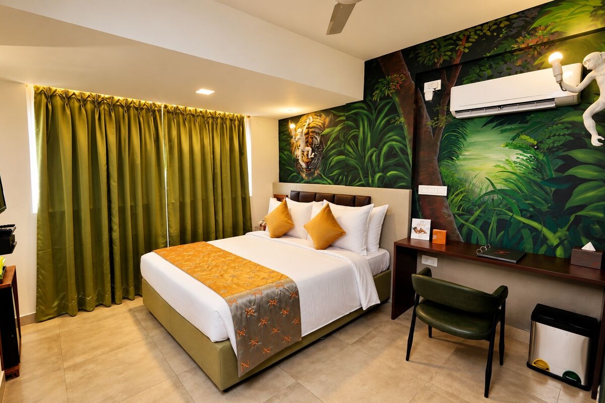 A hotel room with a bed, a desk, a chair, a television, and a wall with a jungle mural.