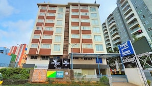 A multi-story hotel with a modern design, featuring a prominent sign for 'Altrust Business Hotel' and another for 'Surya Elegance'. - The Altruist Whitefield Hotel (Bengaluru)