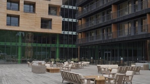 Un bâtiment moderne doté de nombreux balcons, d’espaces de détente en plein air et de grandes fenêtres.