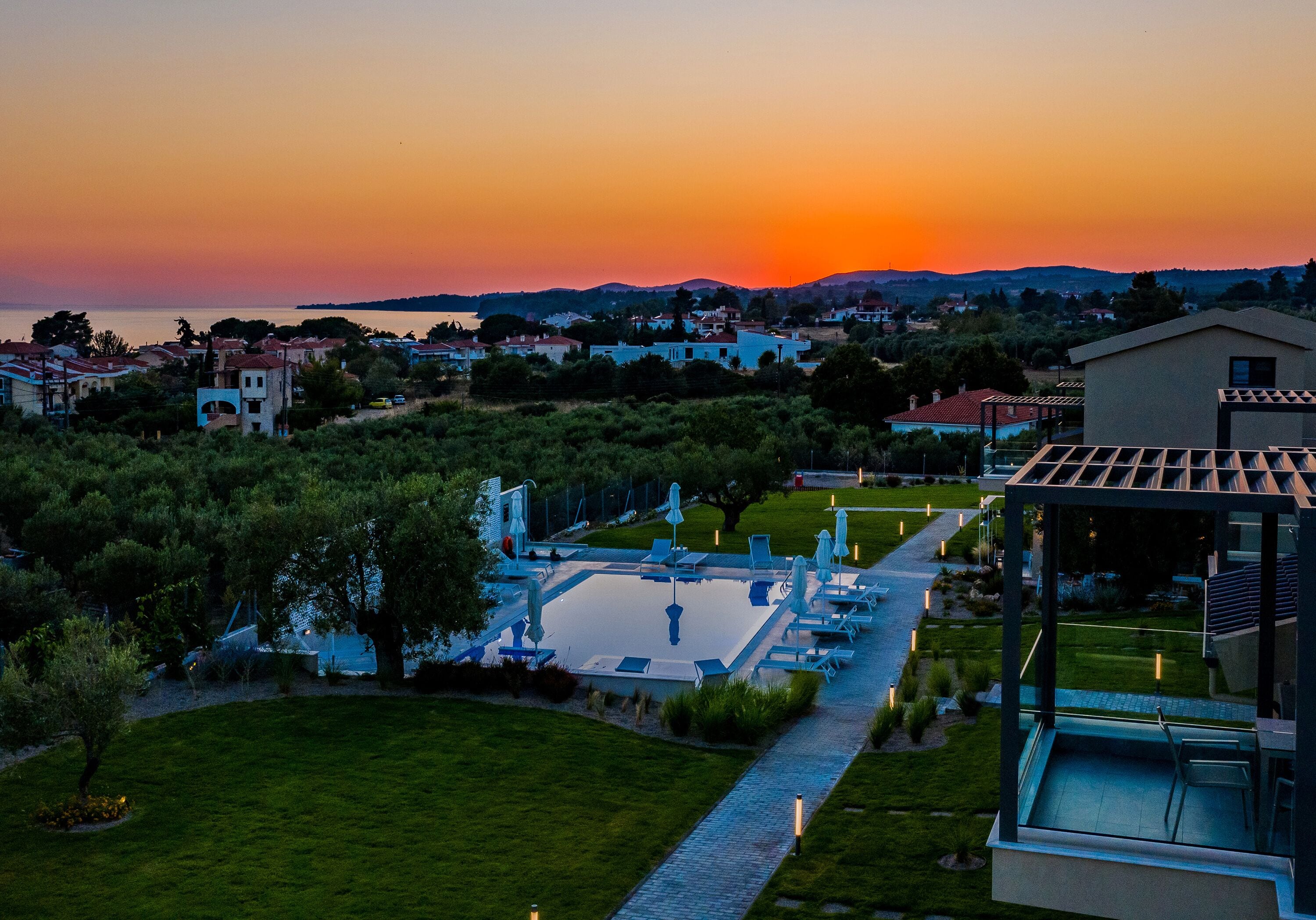 A modern pool area with a clear view of the surrounding landscape and distant hills.