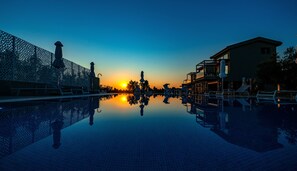 Una piscina al aire libre de temporada, sombrillas