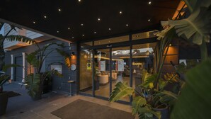 A modern hotel entrance with a reception area, glass doors, and potted plants. - Sea Palm Otel Yalikavak (Bodrum)