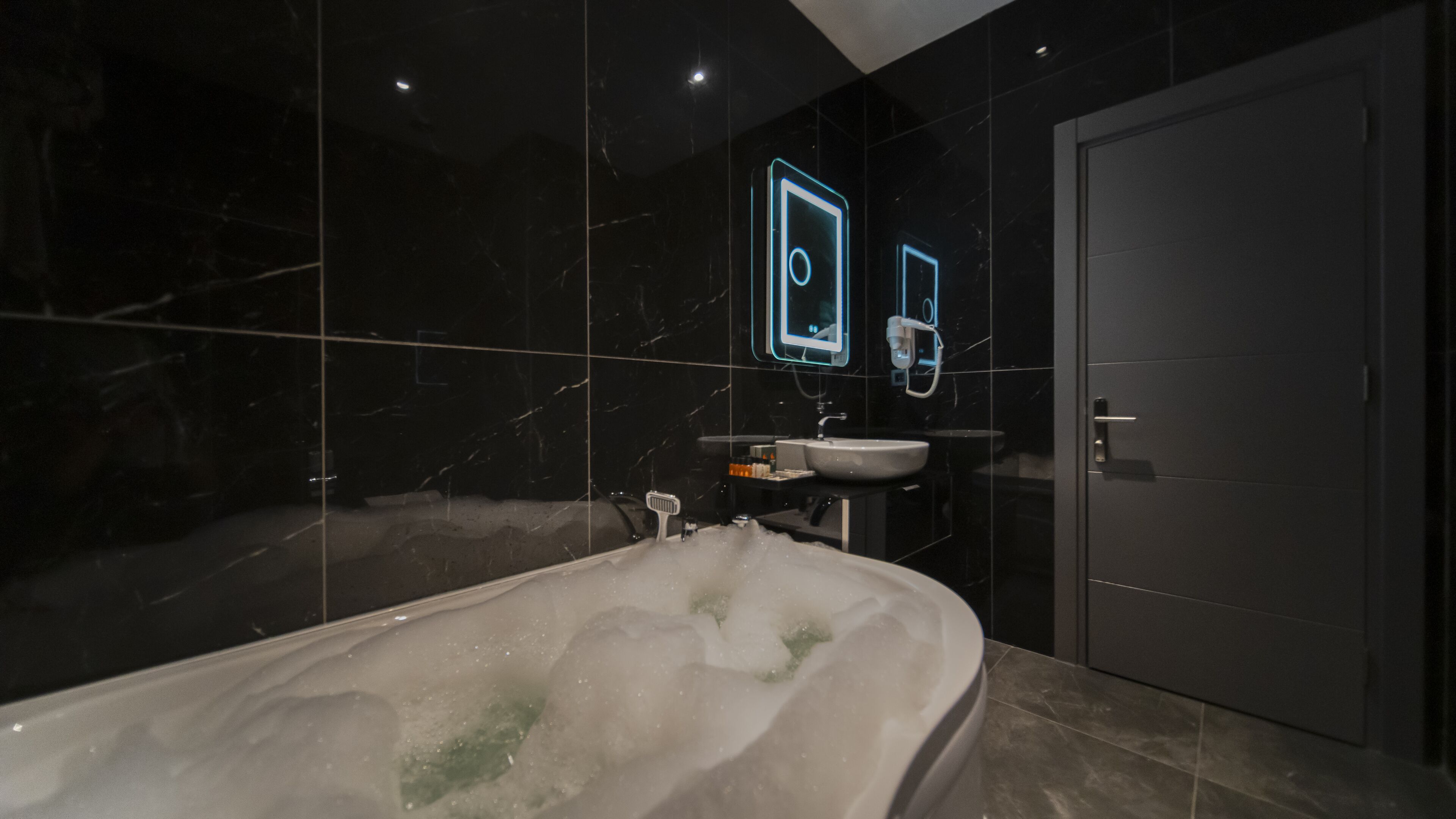 Un bagno moderno con una vasca freestanding, un lavabo e uno specchio.