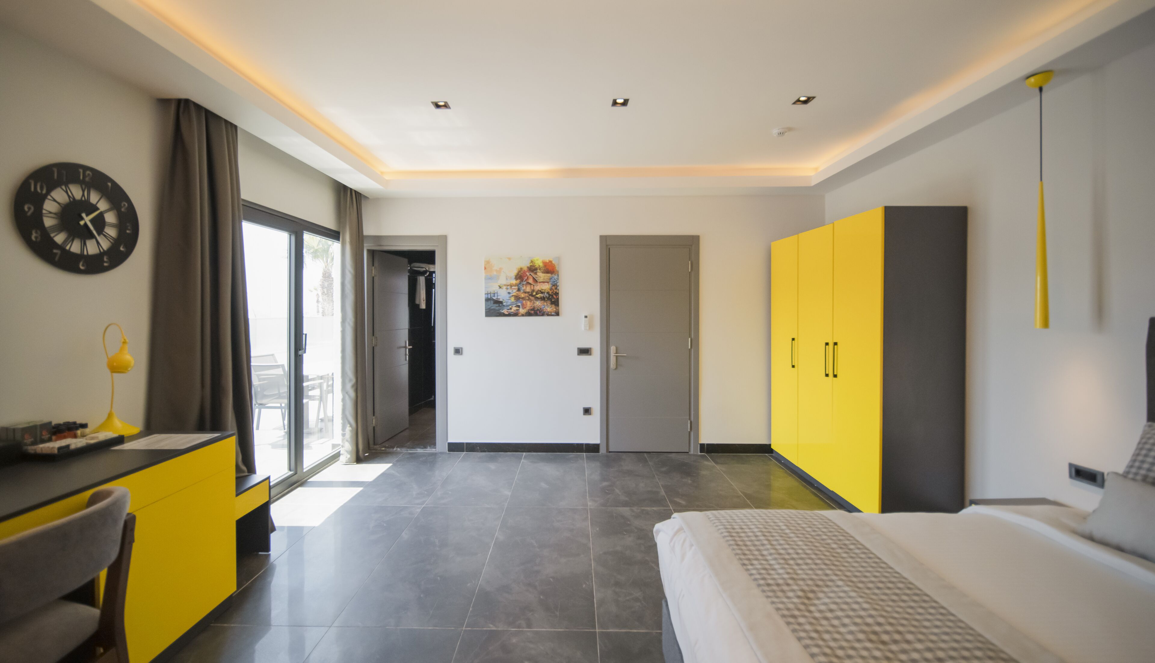 Una habitación de hotel moderna con cama, escritorio y armario.