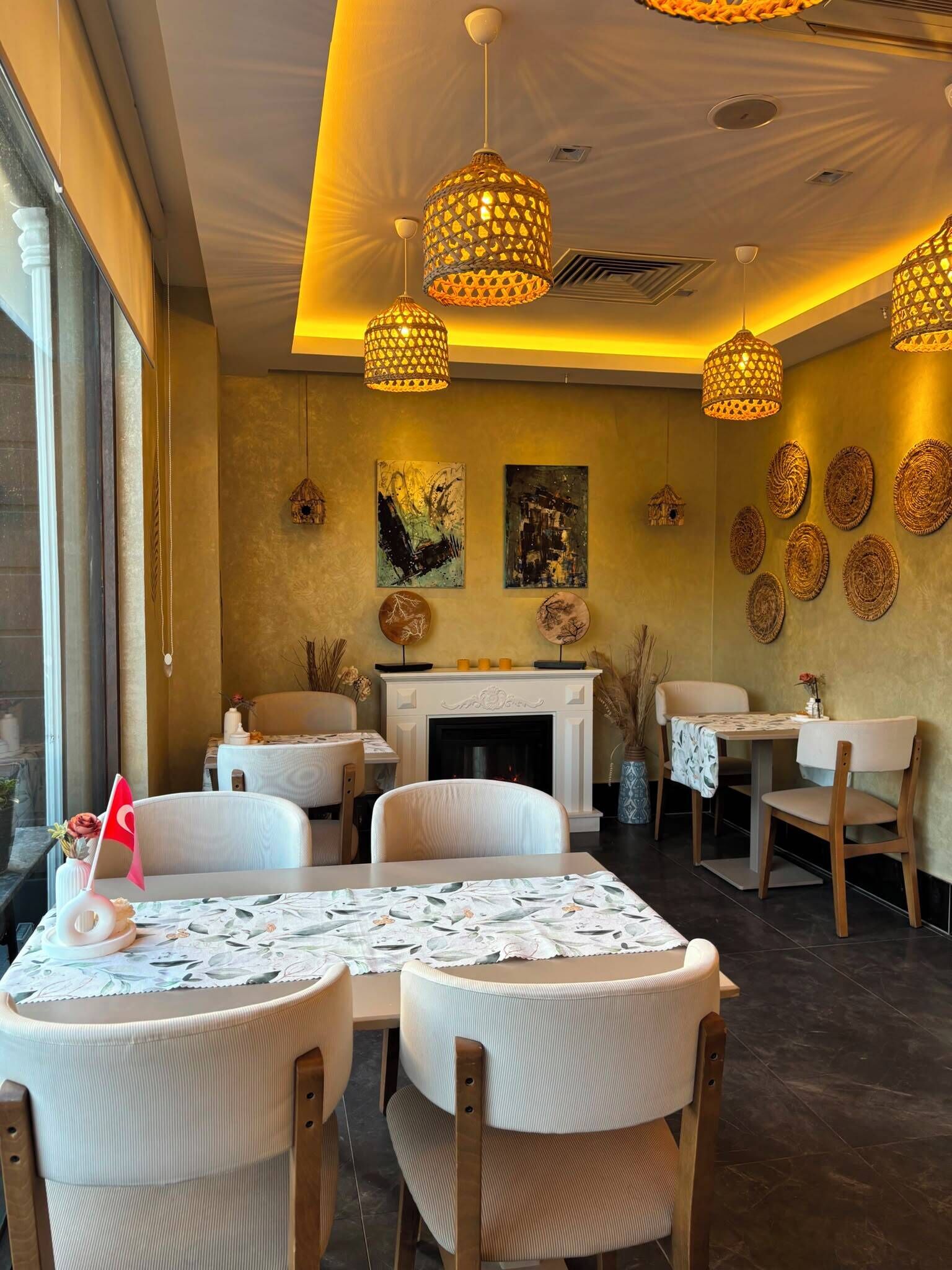 A dining area with round tables, chairs, hanging lamps, and wall decor.