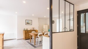 Una cucina moderna con un tavolo di legno, sedie bianche e un forno a incasso.