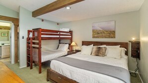 A bedroom with two bunk beds, a wooden headboard, a bedside table with a lamp, and a painting on the wall. - Charming Condo Next To Base Village In Snowmass! Pool, HT, Balcony With Grill, Parking, W&D (Snowmass Village)