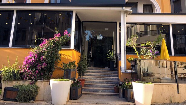 Un edificio con un cartello che riporta la scritta "Aksel Butik Otel" e numerosi balconi.