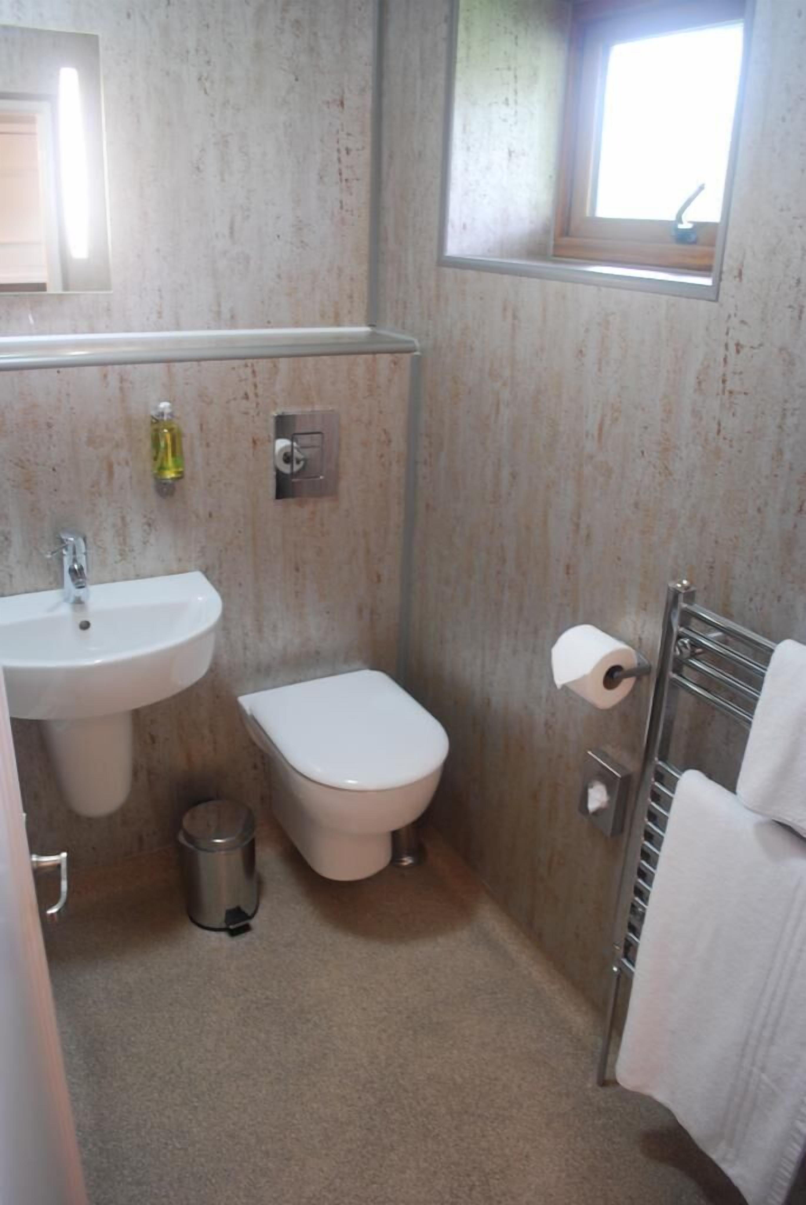 Un baño pequeño con lavamanos, inodoro y ventana.