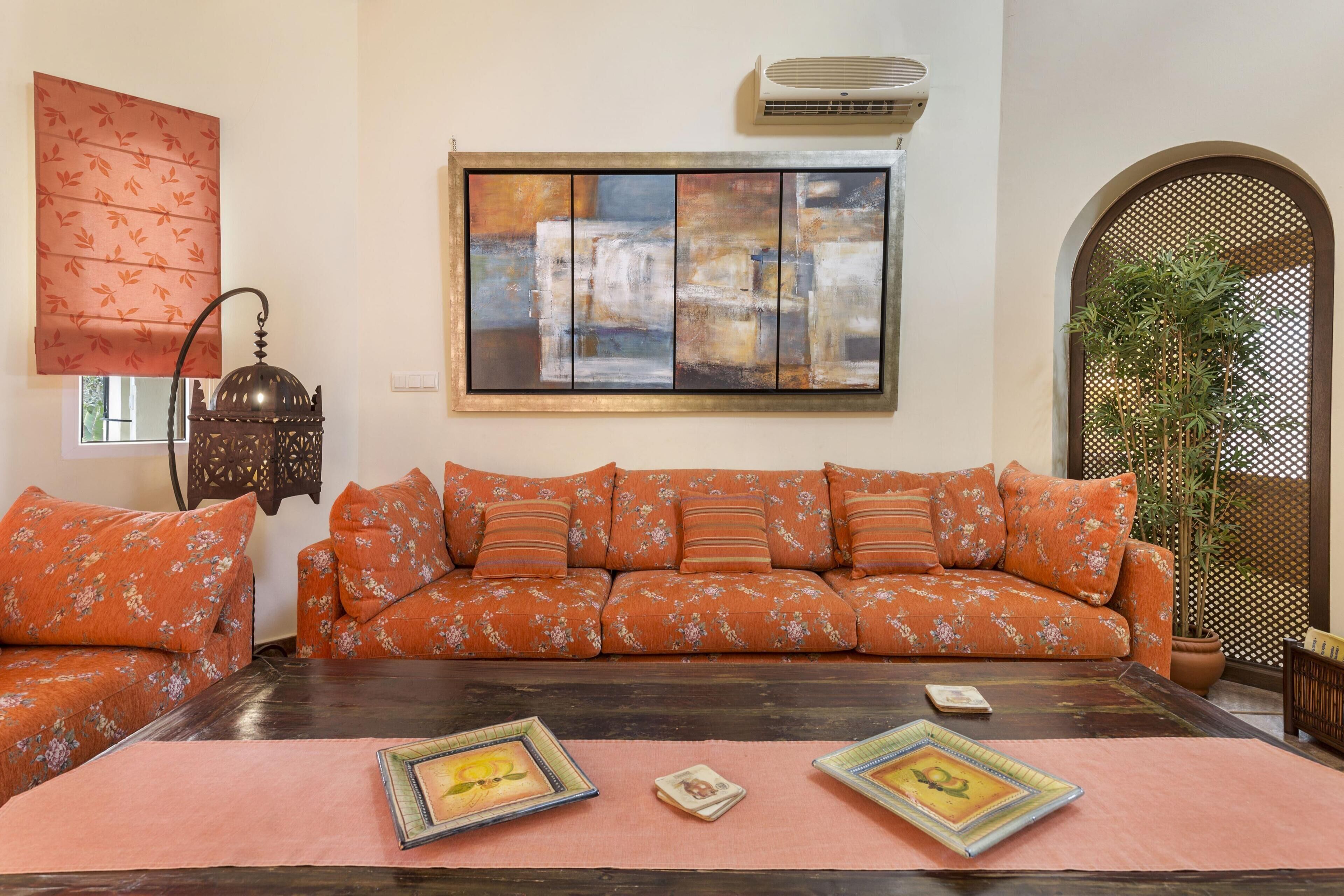 A living room with a sofa set, a coffee table, and a wall-mounted artwork.
