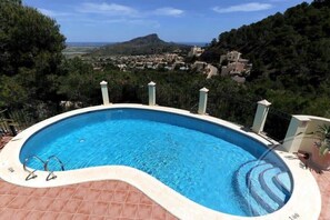 Une piscine offrant une vue sur la ville et, au loin, sur une montagne.