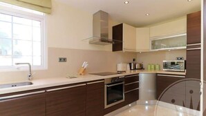 Una cocina moderna con armarios de madera oscura, un horno de acero inoxidable y un microondas.