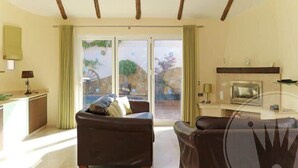 Una sala de estar con chimenea, un sofá y una televisión.