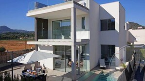 A modern two-story house with a glass balcony, a swimming pool, and outdoor seating. - La Manga Club Las Dalias Villa 564 (La Manga Club, Cartagena)