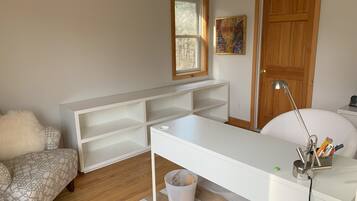 Study room with a large desk, comfortable couch, and ample storage.