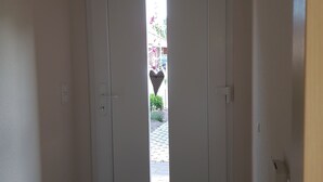 Uma porta branca com uma janela em formato de coração.