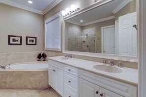 A bathroom with a large bathtub, two sinks, a walk-in shower, and a large mirror. - 14 Gannet Street - Exciting Improvements are underway! (Hilton Head Island)