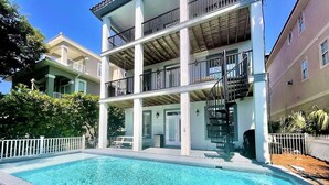A multi-story building with a swimming pool in front. - Luxe Destin Miramar Beach Walk to Beach, Private Heated Pool (Destin)