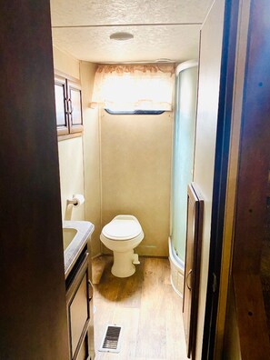 Une petite salle de bain comprenant des toilettes, un lavabo et un meuble de rangement.